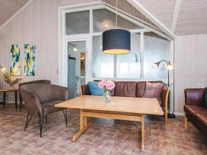a living room with a couch and a table with flowers at 5 star holiday home in Ringkøbing in Ringkøbing
