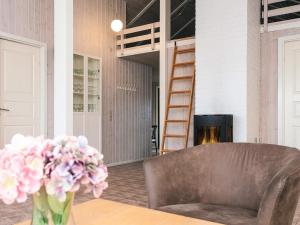 a living room with a couch and a vase of flowers at 5 star holiday home in Ringkøbing in Ringkøbing