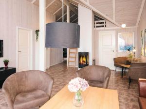 a living room with a table and chairs and a fireplace at 5 star holiday home in Ringkøbing in Ringkøbing