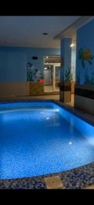 a large blue swimming pool in a building at Узбечка in Tashkent
