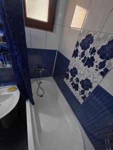 a bathroom with a white bath tub next to a sink at Sunset Home Apartment in Galaţi