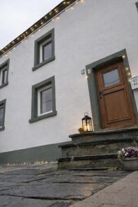 a white house with a door and a light at La petite romantique in Martelange