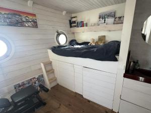 a small room with a bed and a mirror at Stunning boat with a view in Amsterdam +54 photos