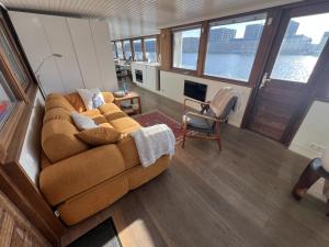 a living room with a brown couch and a table at Stunning boat with a view in Amsterdam