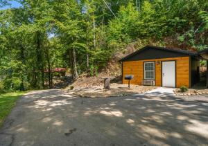 a small cabin with a white door and a driveway at Bird House Pet-Friendly Studio, near Dollywood in Pigeon Forge +3 photos
