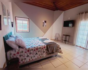 a bedroom with a bed and a television in it at Refúgio dos Pássaros in Gonçalves
