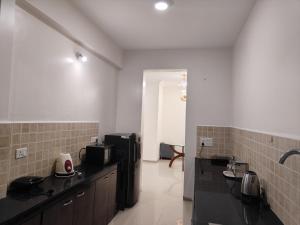 a kitchen with black counter tops in a room at Staeg Meadow View 3BHK - 501 in Indore