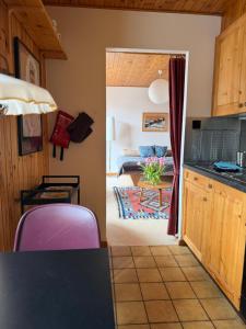 a kitchen and a living room with a couch at Gemütliches Studio im Zentrum in Evolène