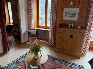a living room with a vase of flowers on a table at Gemütliches Studio im Zentrum in Evolène