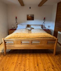 a large wooden bed in a bedroom with wooden floors at Ferienhaus Niederbichler in Gnesau