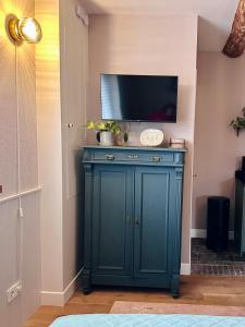 a blue cabinet with a tv on top of it at B&B de Perenboom in Eck en Wiel