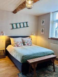 a bedroom with a bed with a bench on it at B&B de Perenboom in Eck en Wiel