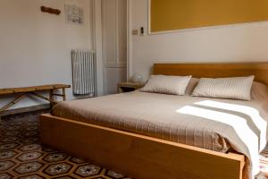 a bedroom with a large bed with a wooden frame at Arena Alfieri B&B in Livorno