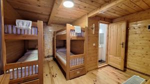 a log cabin with two bunk beds in it at Casa lu` Cojocar in Stulpicani