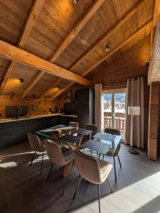 a kitchen with wooden ceilings and a table and chairs at Nevita in Saas-Grund