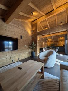 a living room with a wooden wall with a tv at Nevita in Saas-Grund
