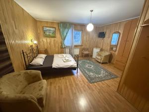 a bedroom with a bed and a couch and a chair at Hotel palas tatariv in Tatariv