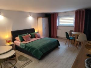 a bedroom with a bed and a table and chairs at Pokoje Koral in Mikołajki