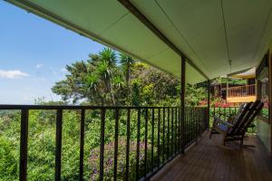 a balcony of a house with a chair and flowers at Mar Inn Costa Rica in Monteverde Costa Rica
