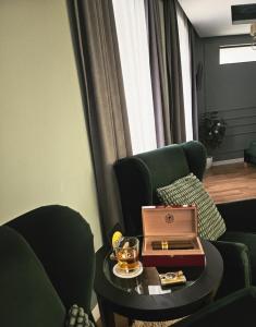 a living room with two chairs and a table with a box on it at Laci lak modern apartment in Oradea