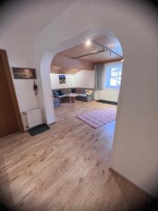 a living room with a wooden floor and an archway at Ferienwohnung Steiner in Scheffau in Scheffau am Wilden Kaiser
