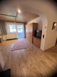 an empty living room with a television and a large window at Ferienwohnung Steiner in Scheffau in Scheffau am Wilden Kaiser