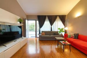 a living room with a red couch and a flat screen tv at Navigli Experience in Milan