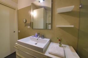 a bathroom with a white sink and a mirror at Navigli Experience in Milan +7 photos