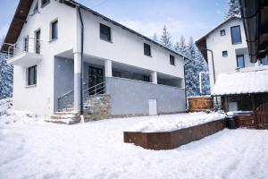 a large white house in the snow at Casa de vacanta Naty in Colibiţa