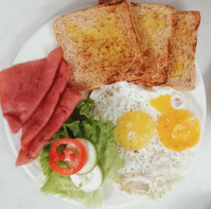 a plate of breakfast food with eggs bacon and toast at Bamboo Payag Batangas in Laurel +7 photos