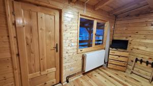 a wooden room with a door and a television at Casa lu` Cojocar in Stulpicani