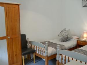 a small room with a bed and a chair at Rosecraddoc Manor - Stable in Saint Cleer +9 photos