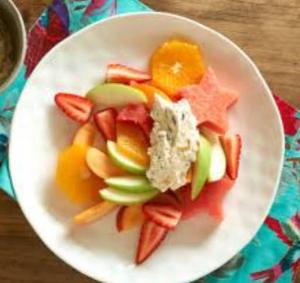 a white plate of fruit and vegetables on a table at Bamboo Payag Batangas in Laurel