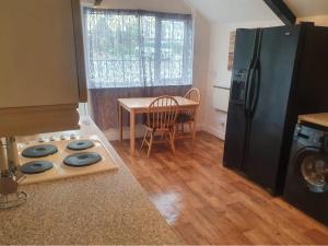 a kitchen with a black refrigerator and a table at Rosecraddoc Manor - Coachman's in Saint Cleer +14 photos
