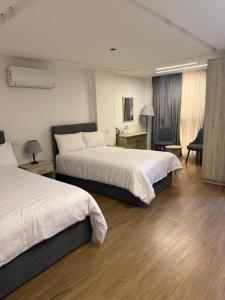 a hotel room with two beds and a desk at الحصرى Elhosary otel in 6th Of October +70 photos