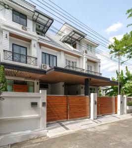 a house with a wooden fence in front of it at Bhumidol Home near Don Muang Airport in Lak Si