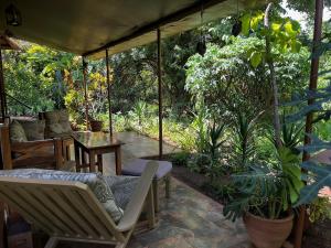 a patio with chairs and a table and trees at Ikweta Safari Camp in Kinna