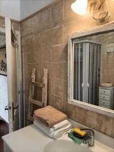 a bathroom with a sink with a mirror and towels at Funtana e Caddos apartment in Berchidda +18 photos