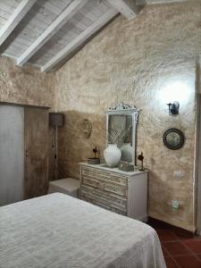 a bedroom with a bed and a dresser and a mirror at Funtana e Caddos apartment in Berchidda