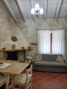 a living room with a couch and a table at Funtana e Caddos apartment in Berchidda