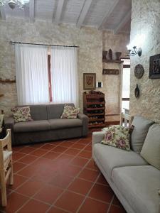 a living room with two couches and a table at Funtana e Caddos apartment in Berchidda