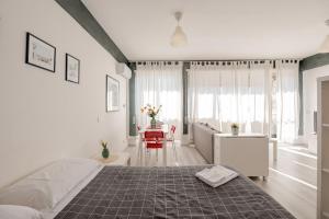 a white bedroom with a bed and a living room at Fratelli Bandiera in Latina