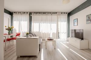 a living room with white furniture and a television at Fratelli Bandiera in Latina