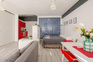 a bedroom with a bed and a kitchen with red cabinets at Fratelli Bandiera in Latina