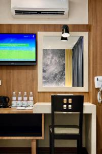 a room with a desk with a television and a chair at Swiss Hotel Kuala Lumpur in Kuala Lumpur