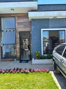 a house with a car parked in front of it at Beach house in Matinhos in Matinhos