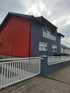 a red and blue house with a white fence at APARTMAN SOFIA in Županja