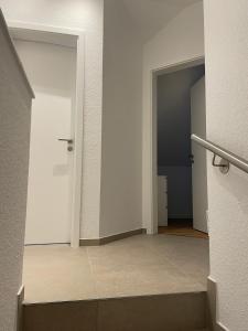 an empty hallway with two doors and a staircase at Seeidylle in Geeste +13 photos
