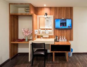 a room with a desk and a tv on a wall at Swiss Hotel Kuala Lumpur in Kuala Lumpur
