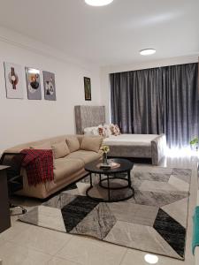 a living room with a couch and a table at Little Haven Stays-Near UN & Two Rivers in Ruaka +26 photos